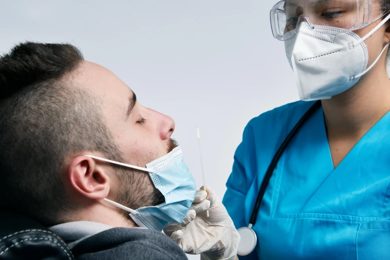 a man with head covering next to a nurse