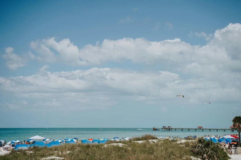 people are walking around the beach area