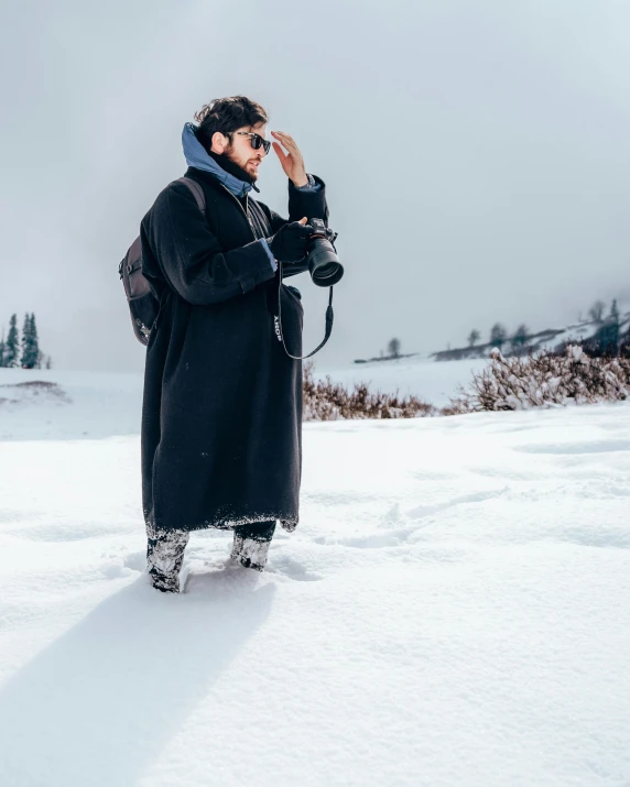 a person in the snow with a camera in hand