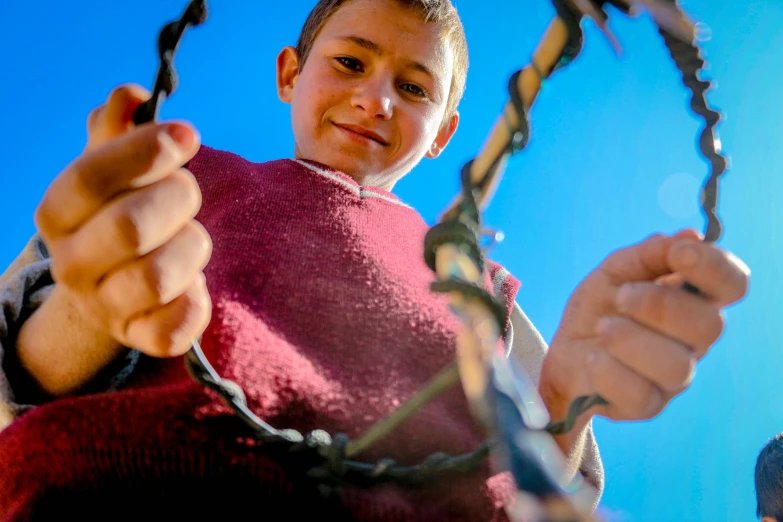 a little boy that is sitting down in a swing