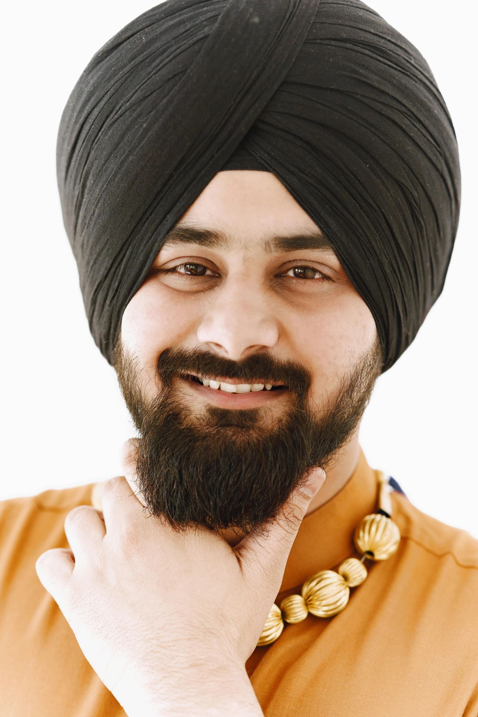 a man wearing a turban with a beard poses for the camera