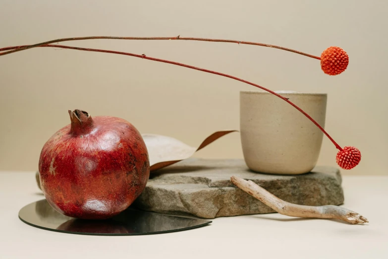 an orange and a pomegranate on top of a stone