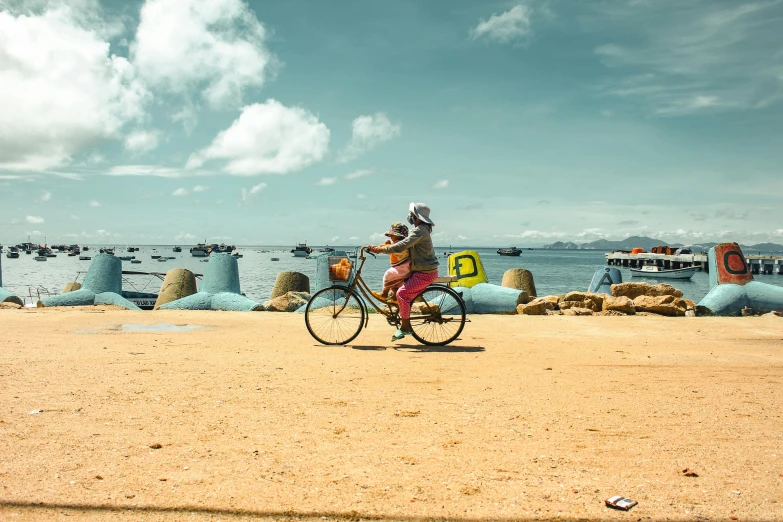 a man on a bicycle is traveling along the beach