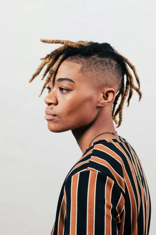 an african american female with short dreadlocks is posing