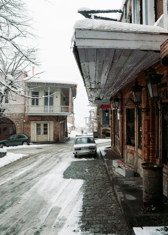 cars driving down a street next to buildings