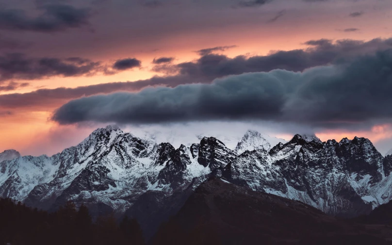 a group of mountains under a cloudy sky
