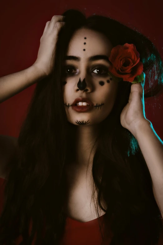 a girl with face painted with an intricate flower and a cross on her forehead