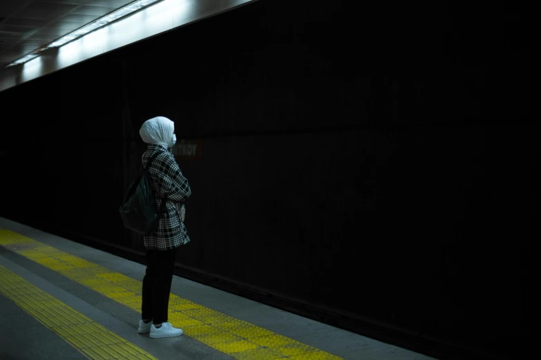 a person standing on the street in a dark space