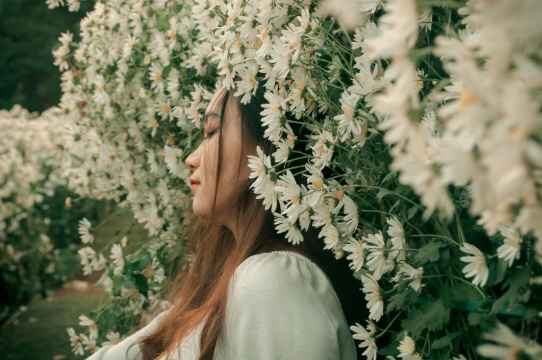 the woman is standing in front of a flowering tree