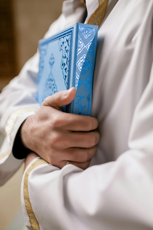 someone is holding out the folded blue tarot