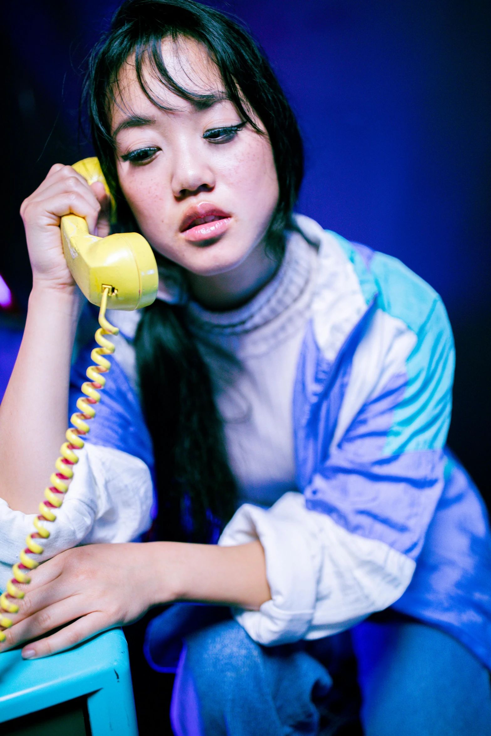 woman sitting with phone at table talking on the phone