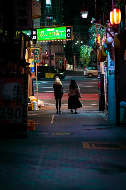 two women walking down the street at night