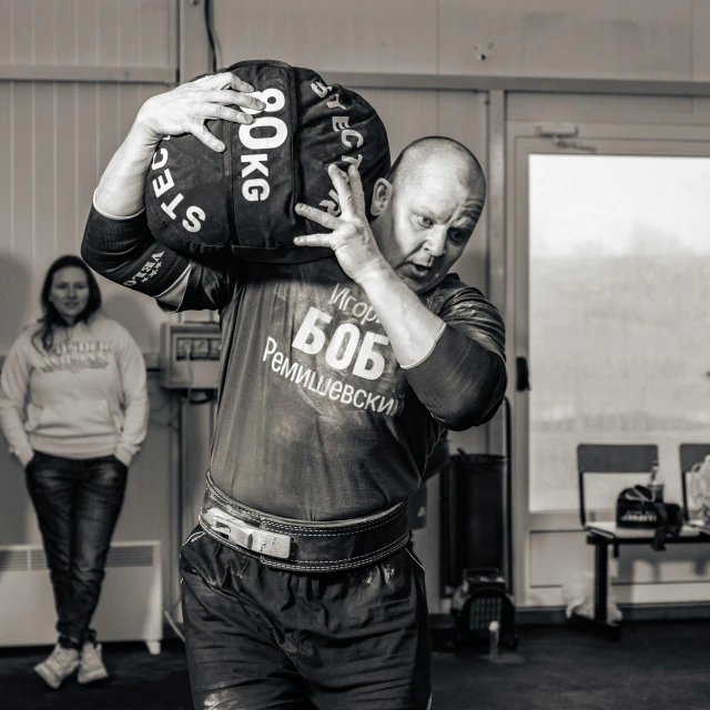 a man in a large bag carrying another man