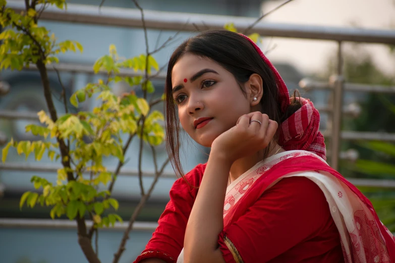 a girl with a beautiful red dress sitting outside