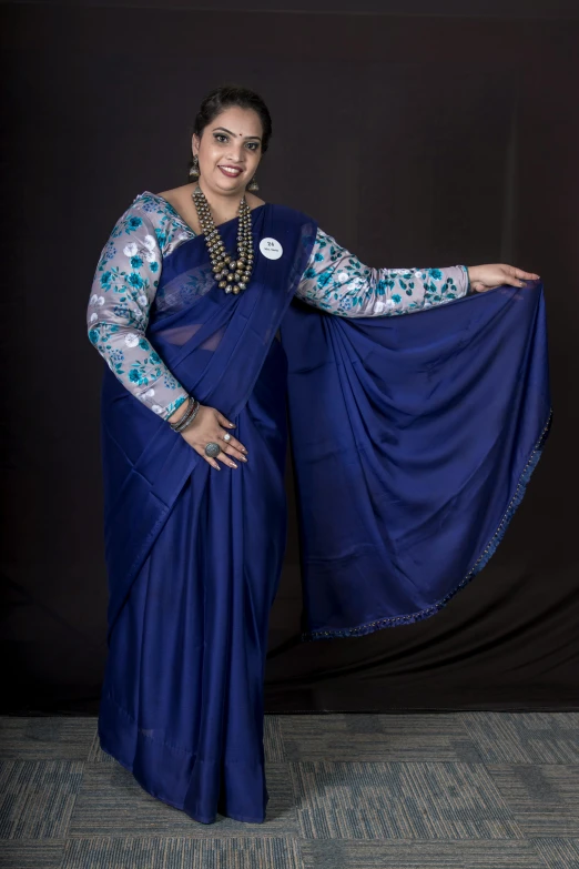 a woman posing for the camera with her blue sari