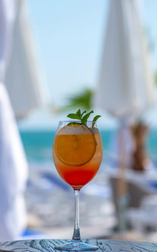 a glass of orange juice with leaves on top