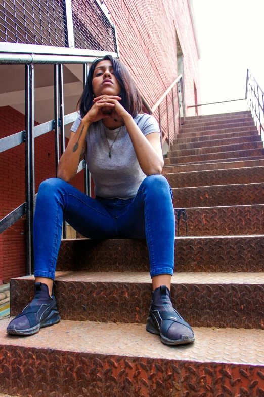 a woman is sitting on the stairs posing for a picture