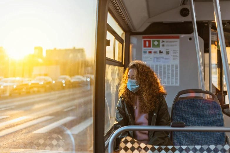 woman in face mask sitting on public transportation