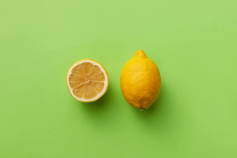 an orange sliced in half next to a whole lemon