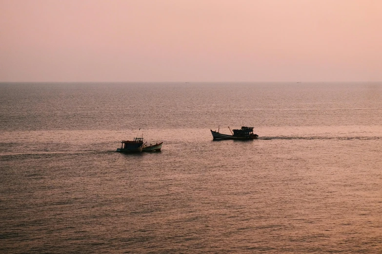 two small boats moving along in the water