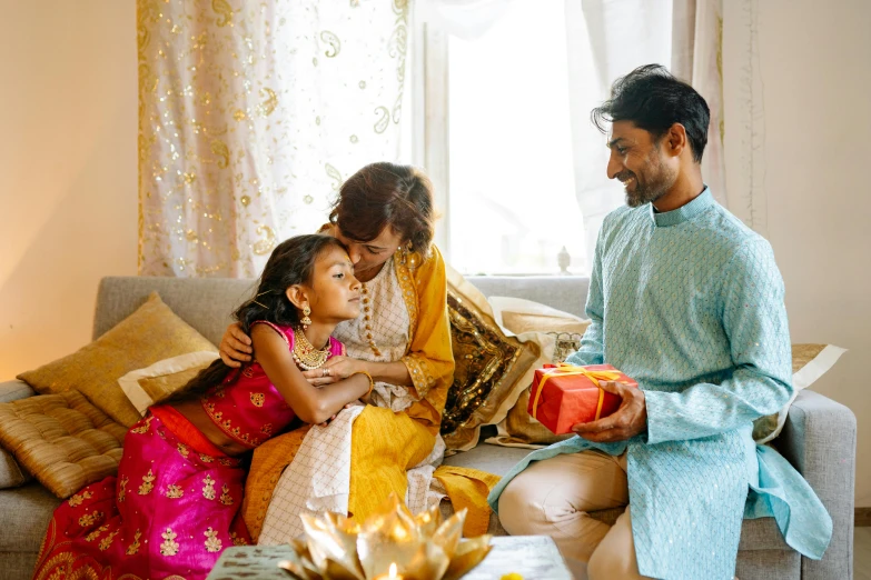 man giving gifts to his children on their sofa