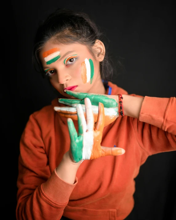 a woman in orange is holding some hands covered in paint