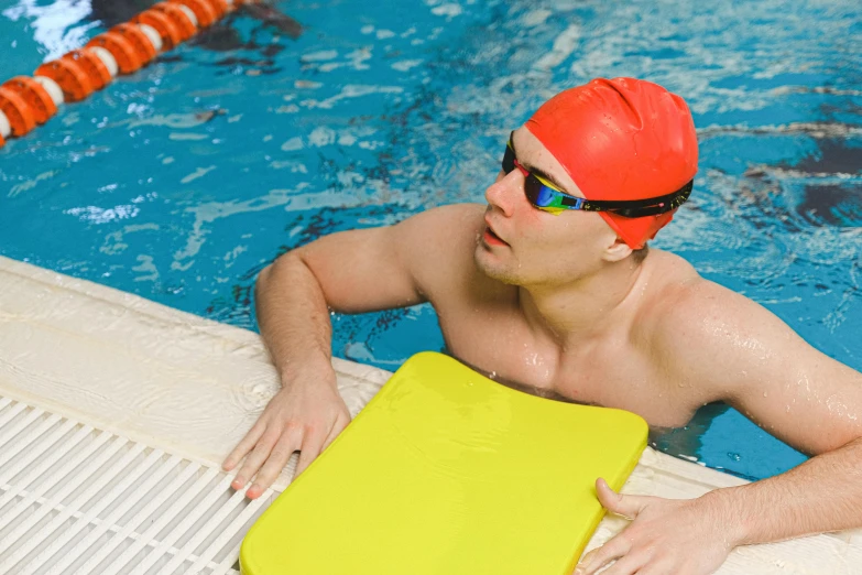 a man wearing a swimming goggles sits by the pool