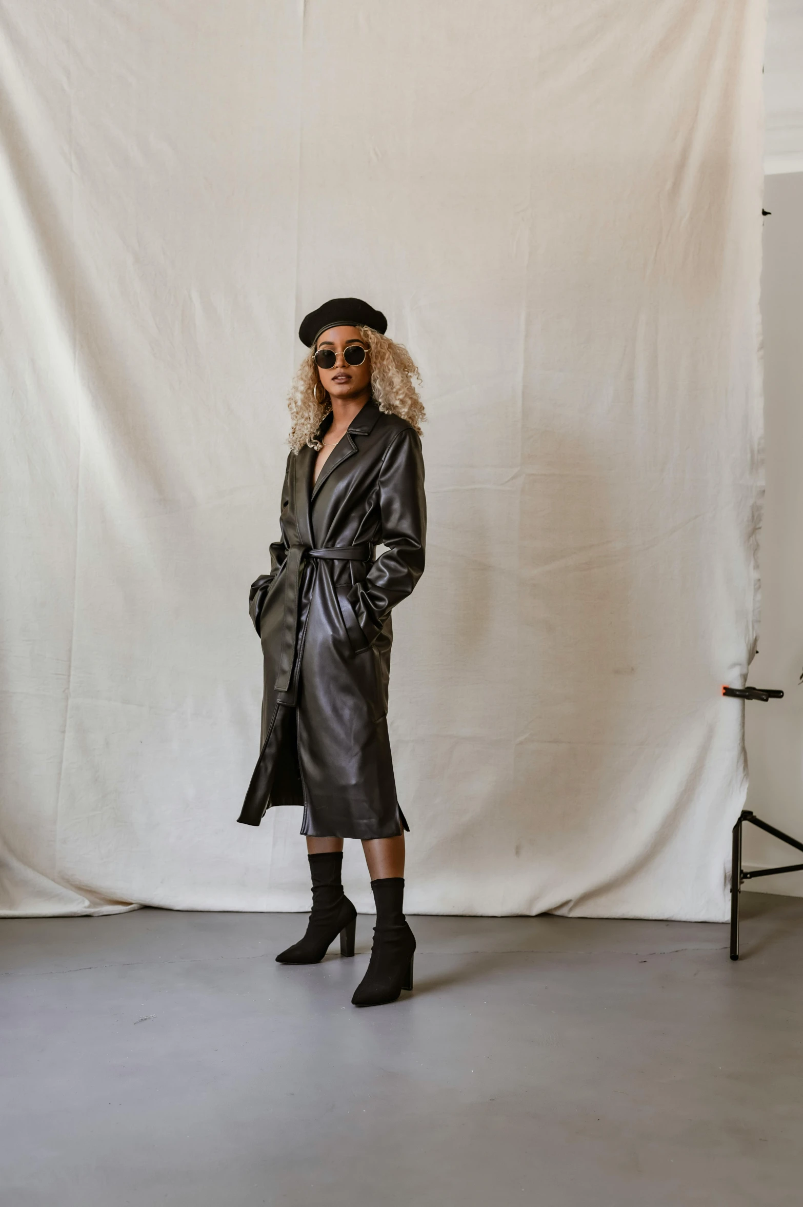 a woman with blonde hair and sunglasses stands in front of a backdrop