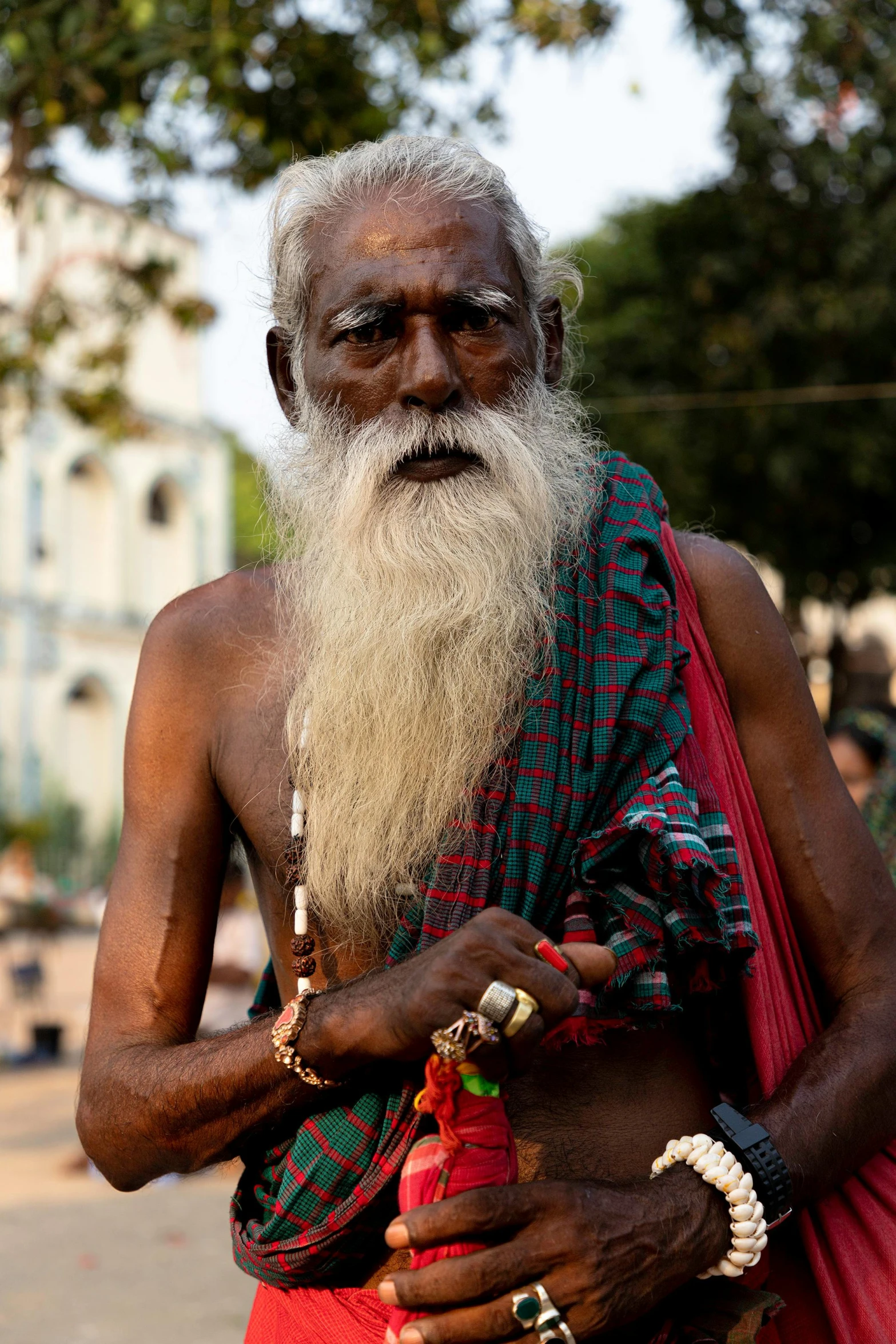 an old indian man holding a red object