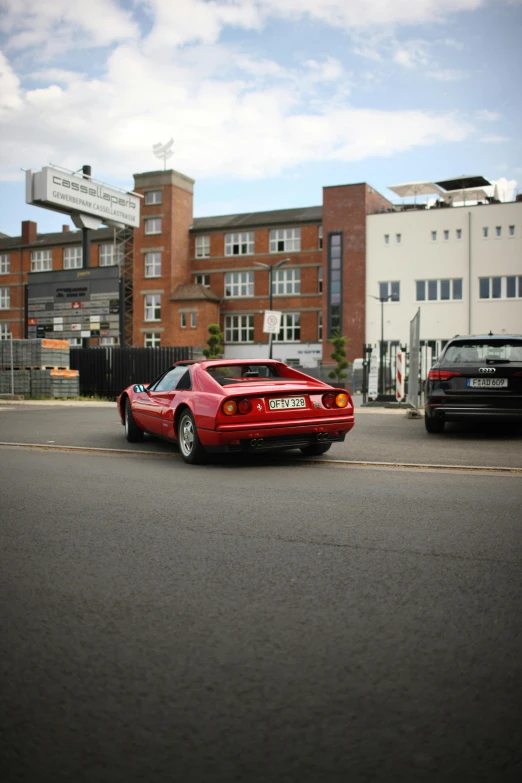 a red sports car is driving in the middle of a road