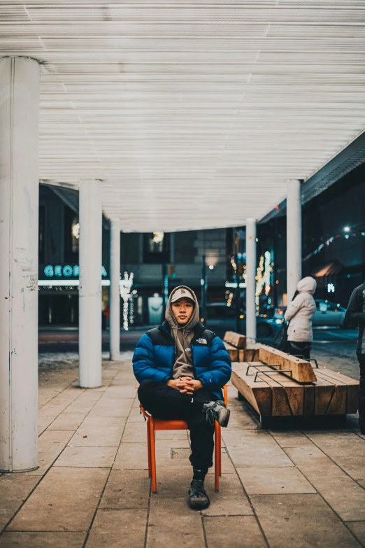 a person sits on a chair and is looking away from the camera