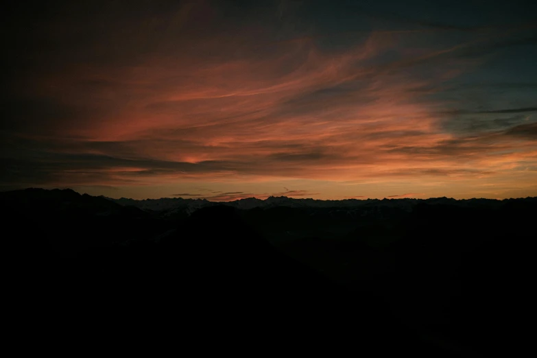 a sunset view over a mountainous plain with trees