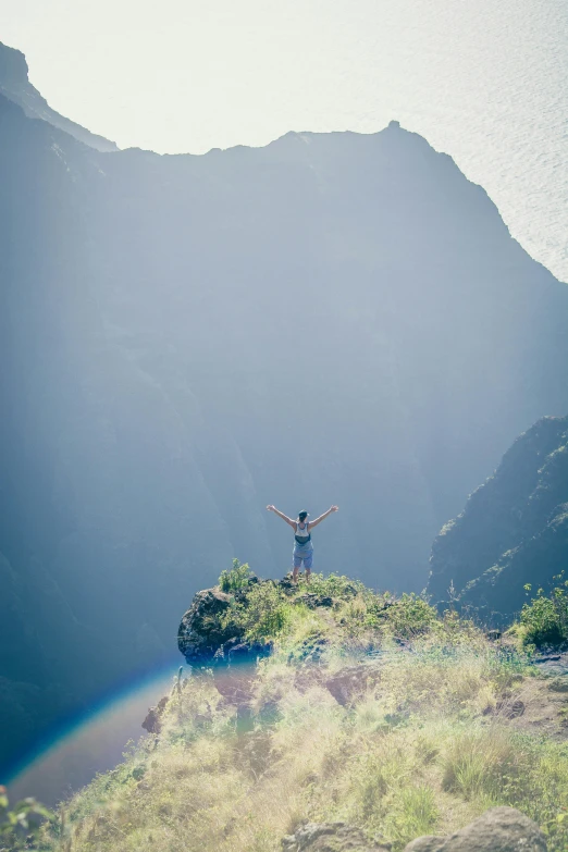 a man standing on top of a grass covered hill