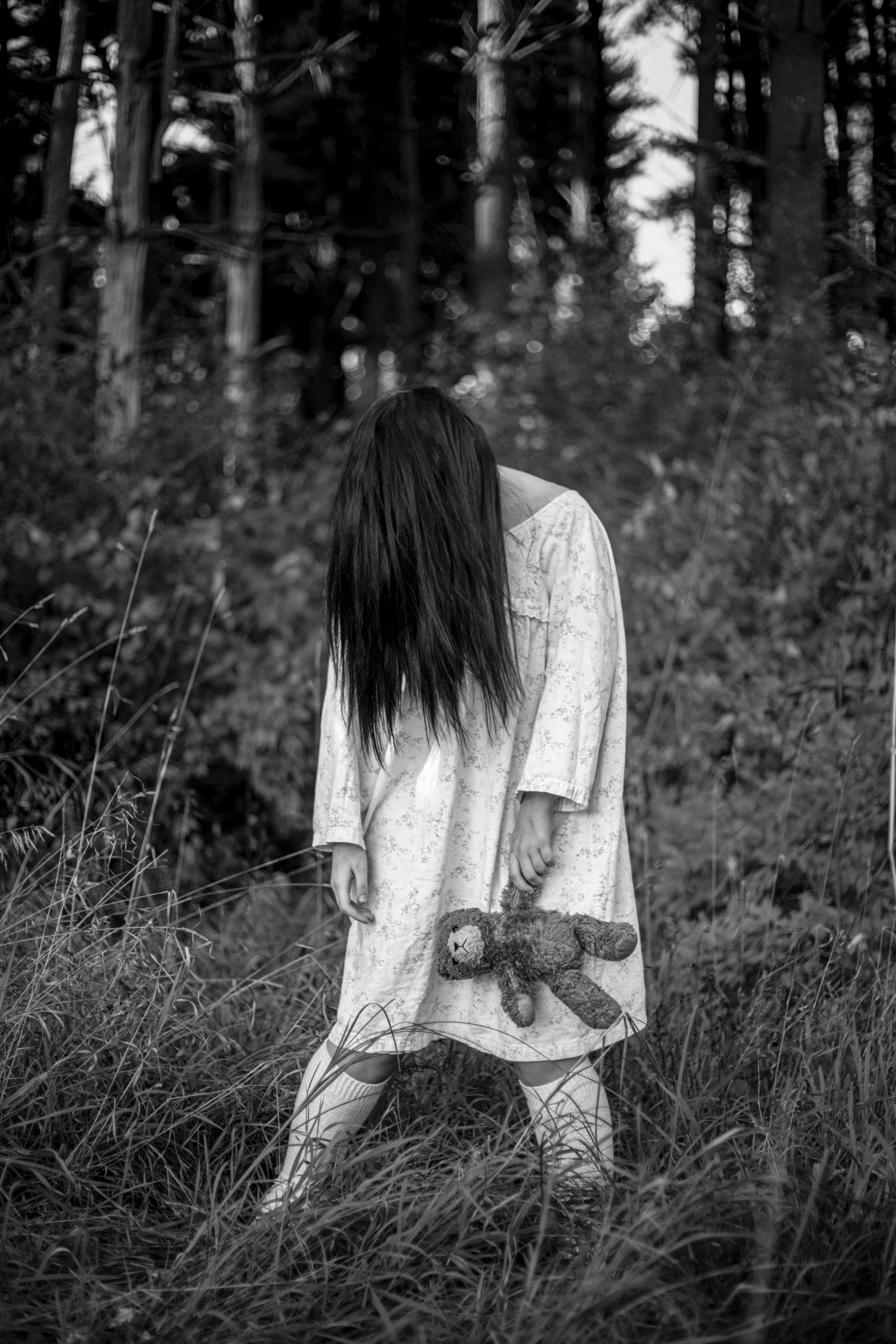 a black and white po of a woman in a forest