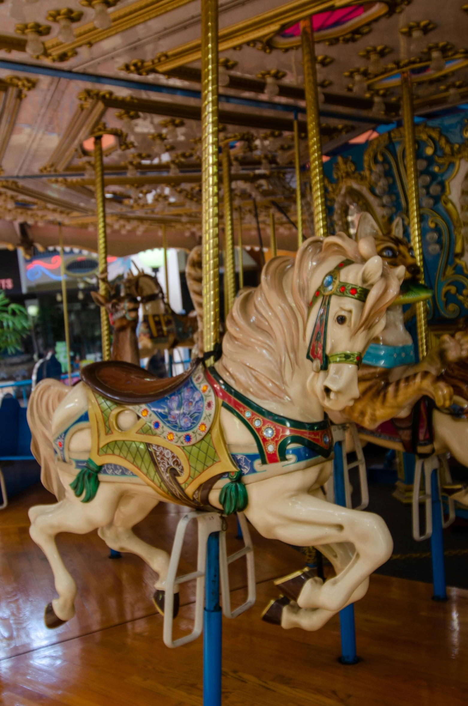 the carousel has two horses riding on the wooden floor