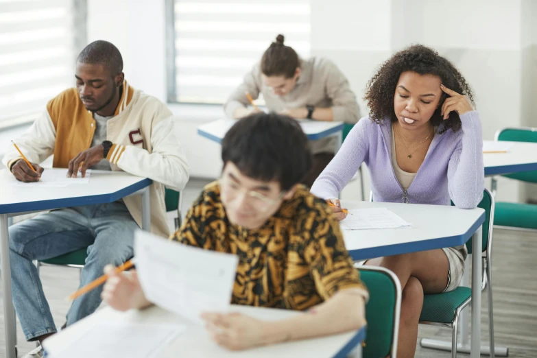 a couple of people sit at desk in the classroom