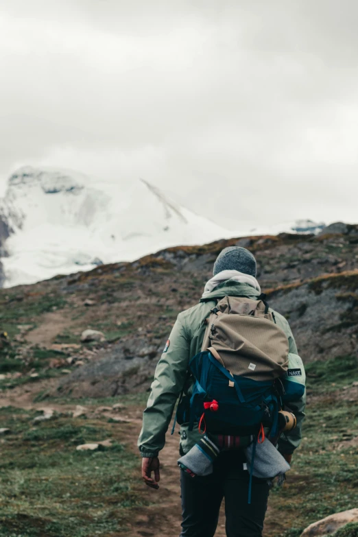 a person standing with backpack on top of a hill