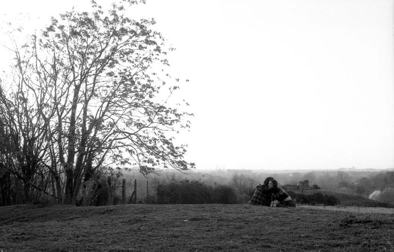 people sitting around on the ground in black and white