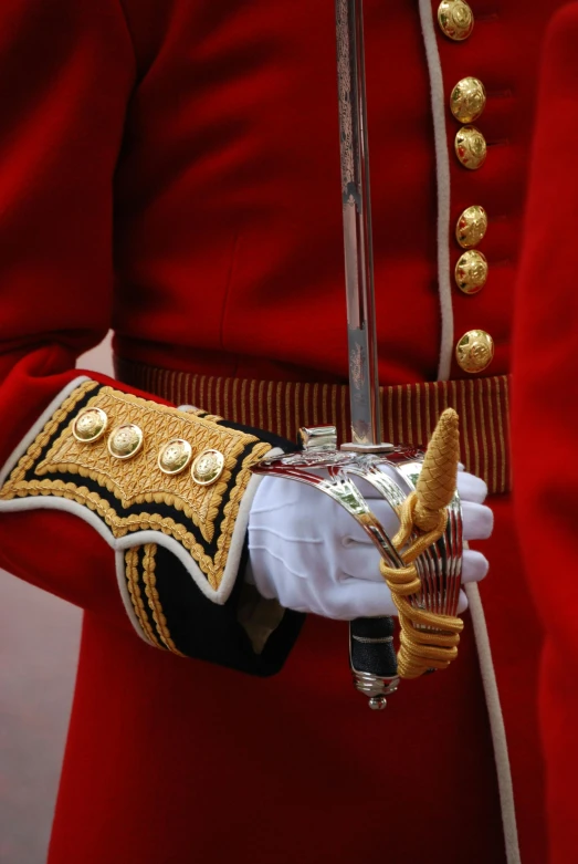 a close up of a person in a uniform holding a sword