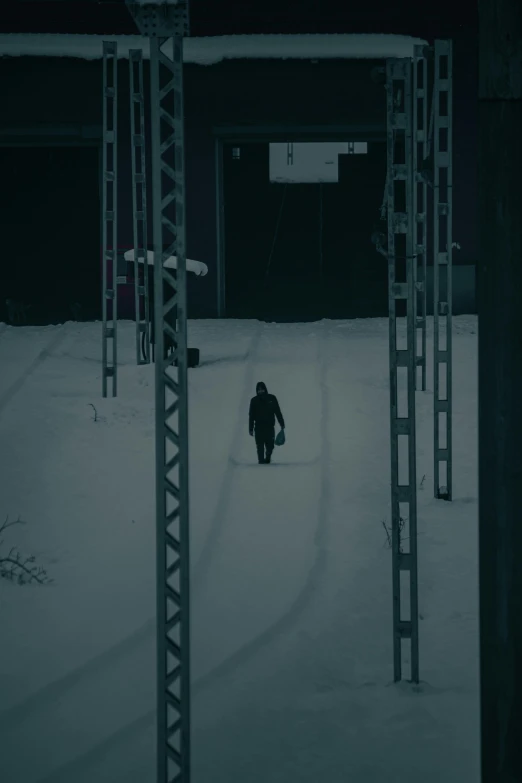 a person walking in snow between poles