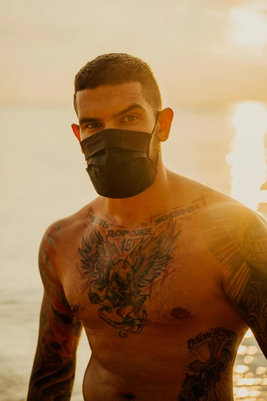 a man with tattoos and a beard is wearing a mask