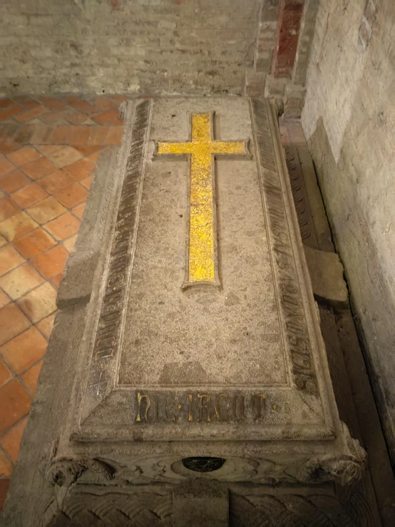 yellow cross on a stone grave in an old church