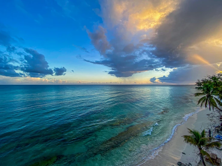 a beach and ocean under a cloudy sky