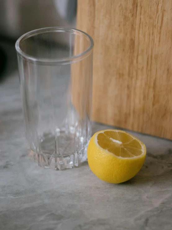 a glass filled with water and half of a lemon