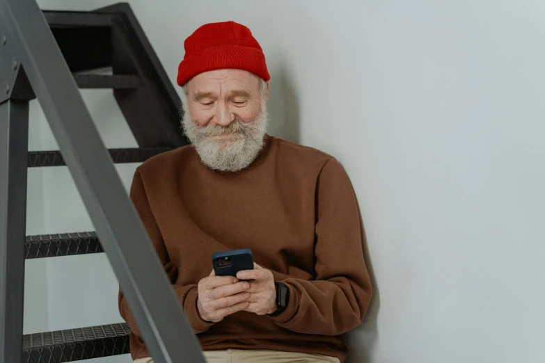 an older man wearing a red hat while looking at a cell phone