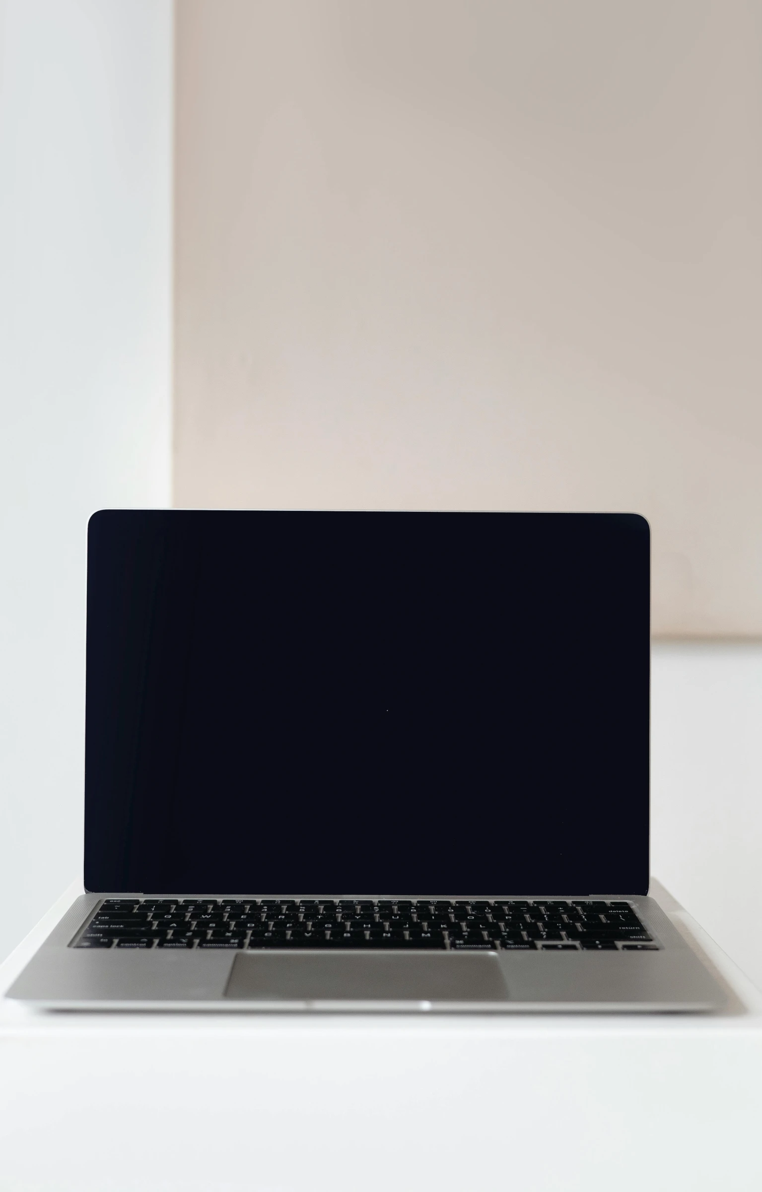 laptop with black screen and mouse sitting on table