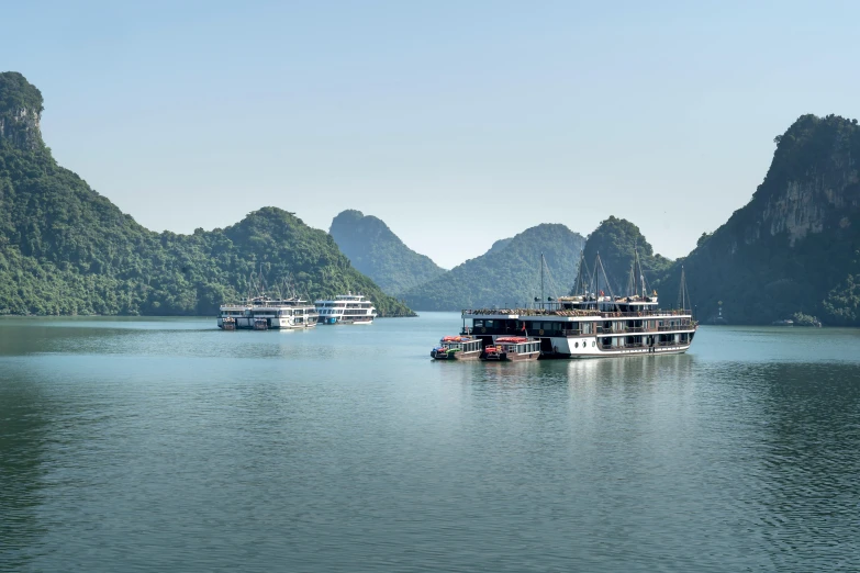 boats floating in the water between some mountain range