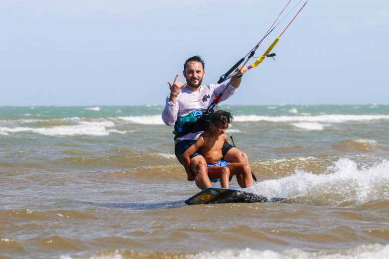 two children hanging out on a para sail attached to a body board