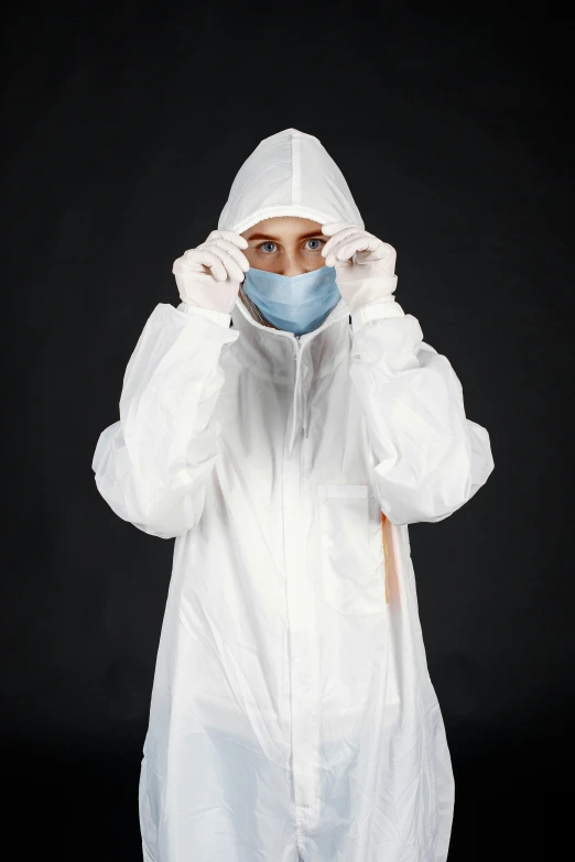 a woman is wearing a white medical gown and a mask