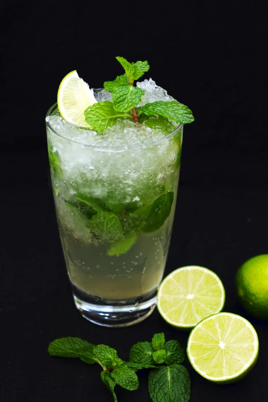 a drink sitting on top of a table next to some mint